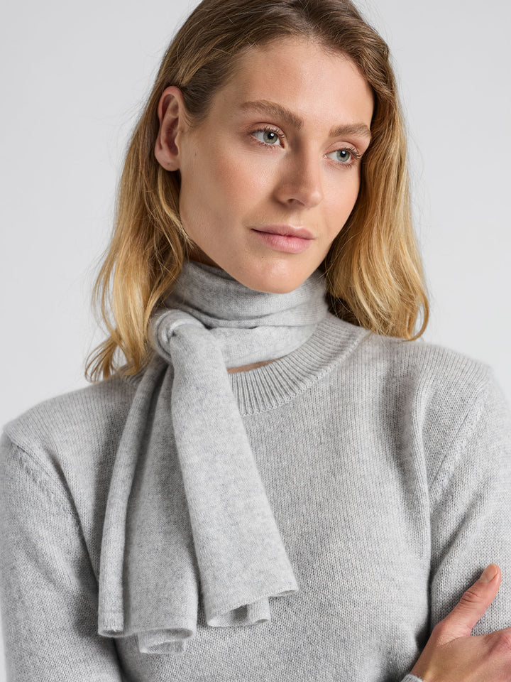 Lite skjerf strikket i 100% ren kashmirull, cashmere. Fullstendig kløfritt. Norsk design fra Kashmina. Farge: Lys grå.